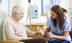 Senior Woman Undergoing Chemotherapy With Nurse