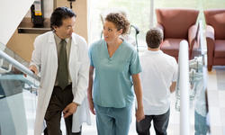 Doctor And Nurse Discussing While Walking On Stair