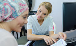 Lady wearing headscarf reading leaflet